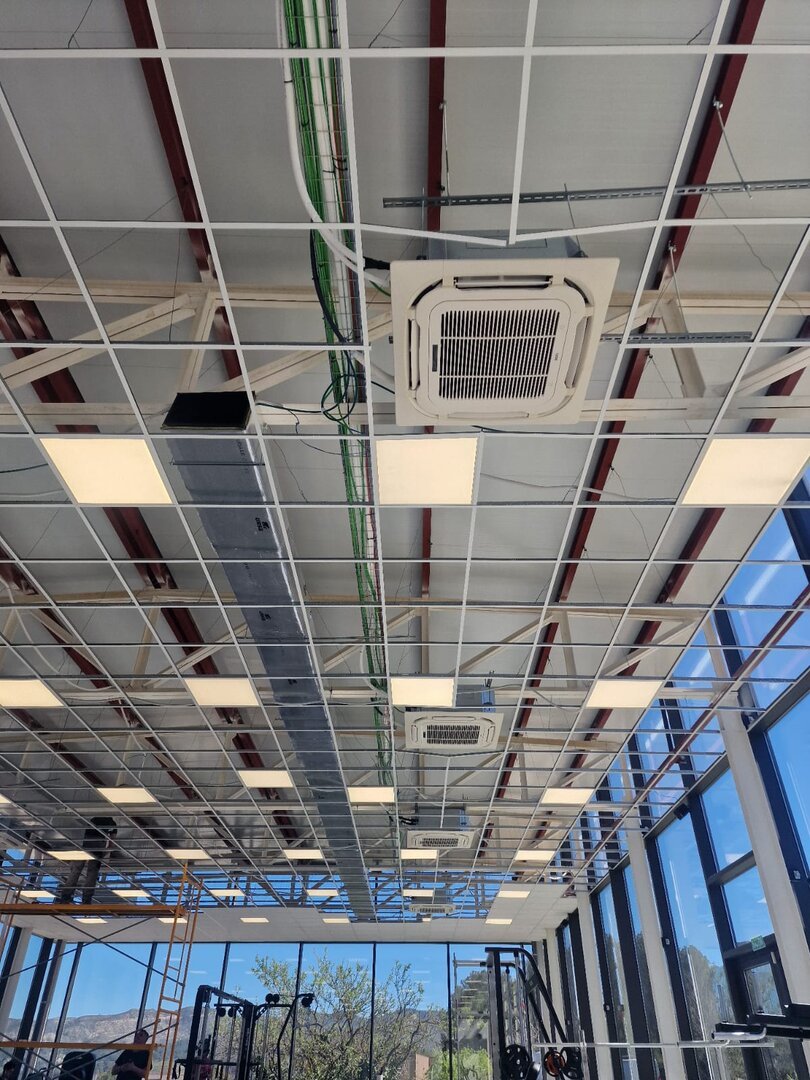 Unidad de aire acondicionado split instalada en techo de oficina con sistema de climatización